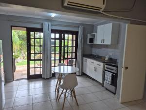 a kitchen with a table and a table and chairs at Fairway Guest Lodge in Margate