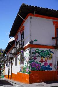 a building with flowers painted on the side of it at Mansión del Parque by CS in Guaranda
