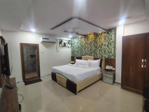 a bedroom with a bed and a painting on the wall at HoTEL MOKSHA GRAND in Vijayawāda