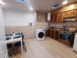 a kitchen with a washing machine and a table at Cantinho do Corgo in Vila Real +14 photos