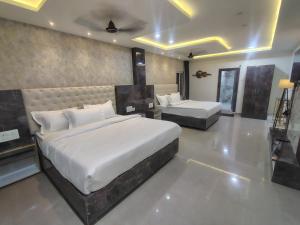 a bedroom with two beds in a room at HoTEL MOKSHA GRAND in Vijayawāda