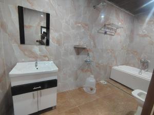a bathroom with a sink and a toilet and a mirror at HoTEL MOKSHA GRAND in Vijayawāda