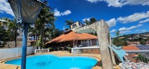 a pool with a water slide in front of a house at Pousada Hotel Casarão SerraNegra in Serra Negra