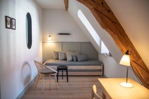 a bedroom with a bed and a table and a chair at Hotel Josef im Kloster Beuerberg in Eurasburg