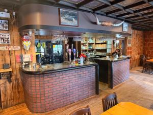 eine Bar in einem Restaurant mit einer Backsteinwand in der Unterkunft Twin Cities Hotel in Turner Valley