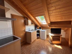 an attic kitchen with a sink and a refrigerator at Appartementhaus Marion in Bad Bayersoien