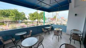 a restaurant with tables and chairs and a large window at Park View Hostel & Suites in Manta