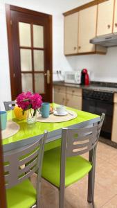 a kitchen with a green table with flowers on it at Apartamento Altamar Portonovo, 100 m playa in Sanxenxo