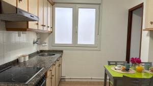 a kitchen with a sink and a table with food on it at Apartamento Altamar Portonovo, 100 m playa in Sanxenxo
