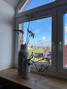 a window with two vases on a wooden window sill at freiheitACHT in Raesfeld