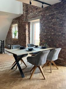 a dining room table with chairs and a brick wall at freiheitACHT in Raesfeld