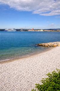 a beach with a rocky shoreline and the water at Abby Apartment Koper in Koper