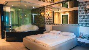 a bedroom with a bed and a tub in a room at Altana Motel in Brasília