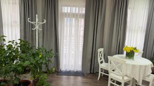 a dining room with a table and chairs and curtains at La casa di Elena in Reni