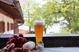 a glass of beer sitting next to a plate of food at Ferienwohnungen Thomafischer in Chieming