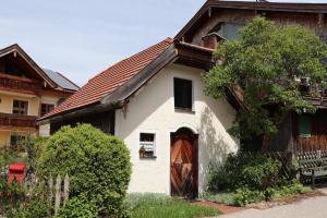 a small white house with a brown roof at Ferienwohnungen Thomafischer in Chieming