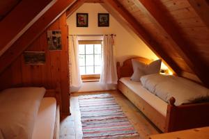 a attic room with two beds and a window at Ferienwohnungen Thomafischer in Chieming