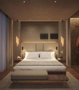 a bedroom with a large bed with a bench in it at The Bank by MYR Hotels in Valencia
