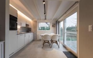 a kitchen with a table and chairs and a large window at Boszicht 32 in De Haan