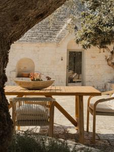 a wooden picnic table with a bowl of flowers on it at TRULIVO in Monopoli