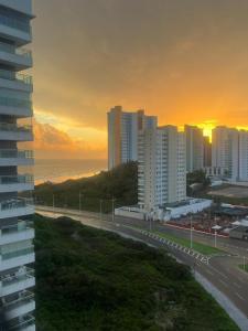 a sunset over a city with a highway and buildings at Flat Biarritz - Praia Litorânea in São Luís