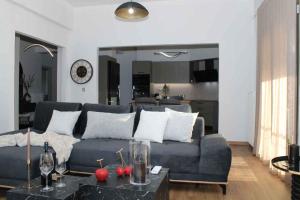 a living room with a blue couch and a table at Theasis apt in Neméa
