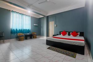 a bedroom with a bed with red pillows on it at Hotel O SPRINGVILLA in Dispur