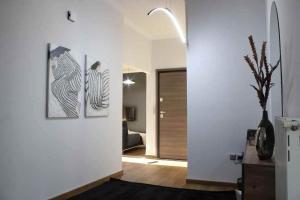a living room with three paintings on the wall at Theasis apt in Neméa +80 photos