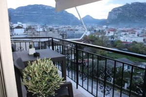 a balcony with a table and a view of a city at Theasis apt in Neméa