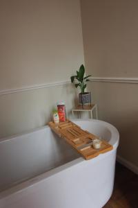 a bath tub with a wooden tray on top of it at Maison Pistache in Le Dorat