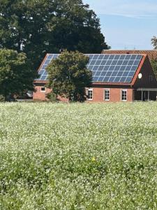 a barn with solar panels on the roof in a field at Landidyll Georg in Ostbevern