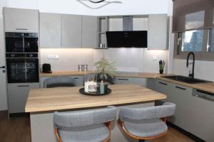 a kitchen with a wooden table and two chairs at Theasis apt in Neméa