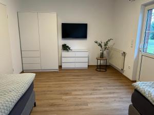 a bedroom with two beds and a tv on a wall at Landidyll Georg in Ostbevern