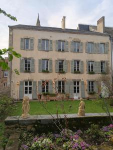 a large house with statues in front of it at Maison Pistache in Le Dorat