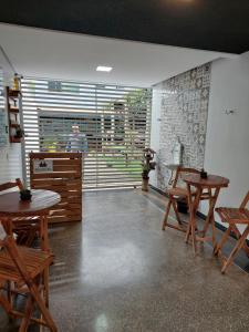 a room with tables and chairs and a man in the background at Suíte Big Família - Queens Hotel in Formosa