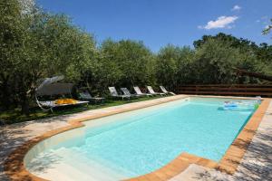 a swimming pool with lounge chairs in a backyard at Scappo in Umbria, Eva in Fornole