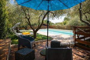 a patio with chairs and an umbrella next to a pool at Scappo in Umbria, Eva in Fornole +40 photos