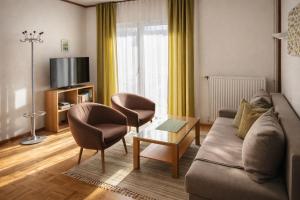 a living room with a couch and two chairs at Ferienwohnungen Vidoni in Bodensdorf