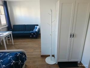 a living room with a blue couch and a table at Gryfhaus - Pokój Kapitański, 19m2, blisko plaży, parking, wysoka ocena 9,5, 2-4 osoby in Międzyzdroje