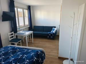 a room with a bed and a couch and a table at Gryfhaus - Pokój Kapitański, 19m2, blisko plaży, parking, wysoka ocena 9,5, 2-4 osoby in Międzyzdroje