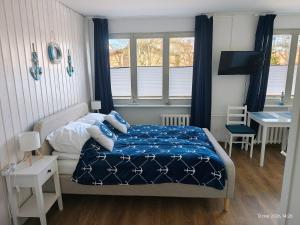 a bedroom with a bed and a desk and windows at Gryfhaus - Pokój Kapitański, 19m2, blisko plaży, parking, wysoka ocena 9,5, 2-4 osoby in Międzyzdroje