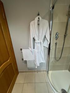 a robe hanging in a shower in a bathroom at Copper Beeches in Elgin +9 photos