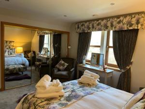 a hotel room with towels on a bed and a mirror at Copper Beeches in Elgin