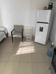 a kitchen with a white refrigerator and a chair at Margaritas in Cancún