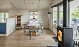 a living room with a fireplace and a table and chairs at VE134-Vejers-Strand-Jafdalvej-89 in Vejers Strand