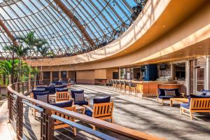a lobby with chairs and a glass ceiling at Harrah's Resort Atlantic City, A Caesars Destination in Atlantic City