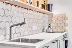 a kitchen with a sink and a tiled wall at O'Hara in Horní Blatná