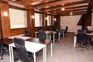 a dining room with tables and chairs and windows at Балкан вили in Ribarica