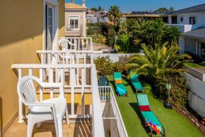 a balcony with chairs and a slide on the grass at Villa dos Teixos in Cascais