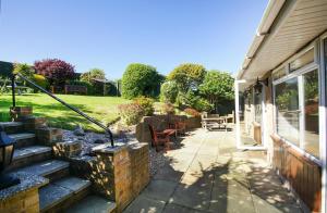 a patio of a house with a fire place at Dean Court Garden - Parking - by Brighton Holiday Lets in Rottingdean